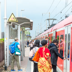 Resiende drängen sich auf dem schmalen Bahnsteig in Kerpen Sindorf