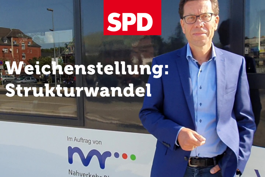 Dierk Timm vor einer Bahn mit NVR Aufdruck. Text: Weichenstellung: Strukturwandel