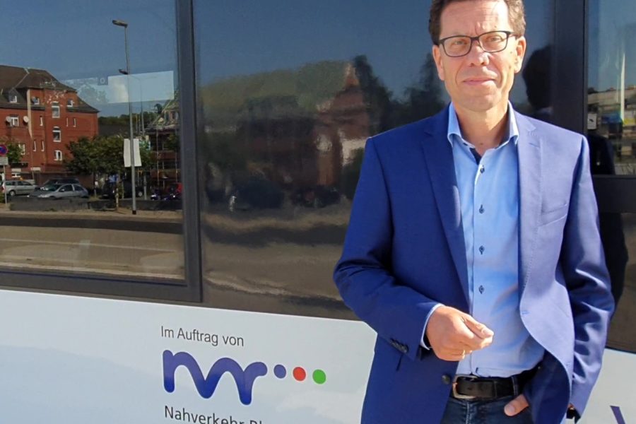Dierk Timm vor Regionalbahn mit NVR Logo